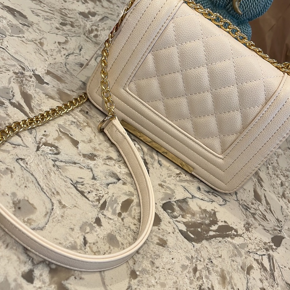 Beige crossbody purse with gold buckle strap